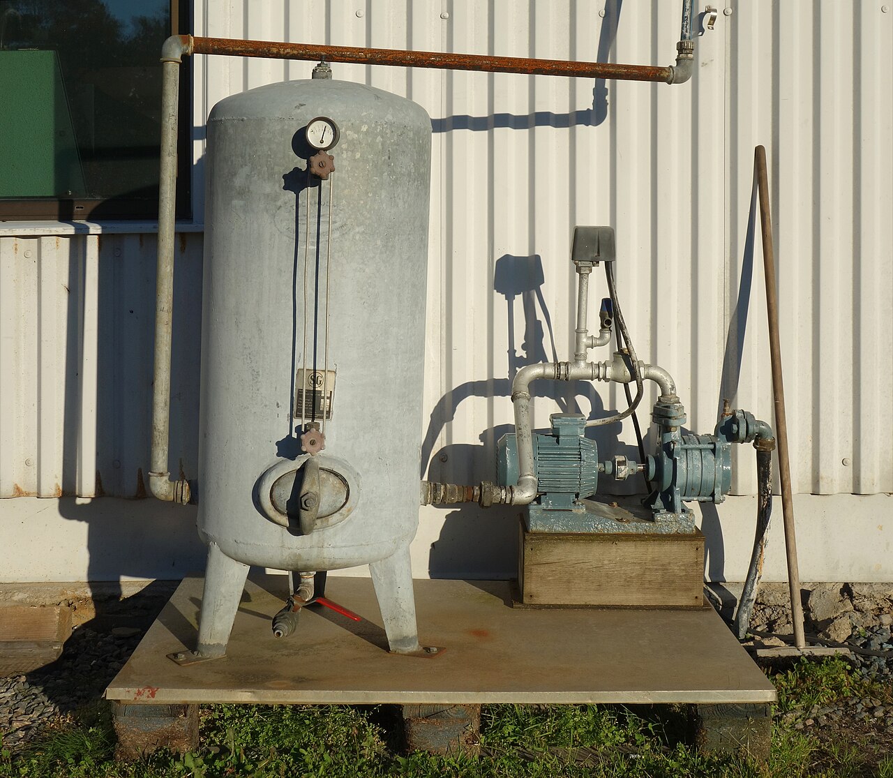 Photograph of a real water pressure vessel beside a jet pump