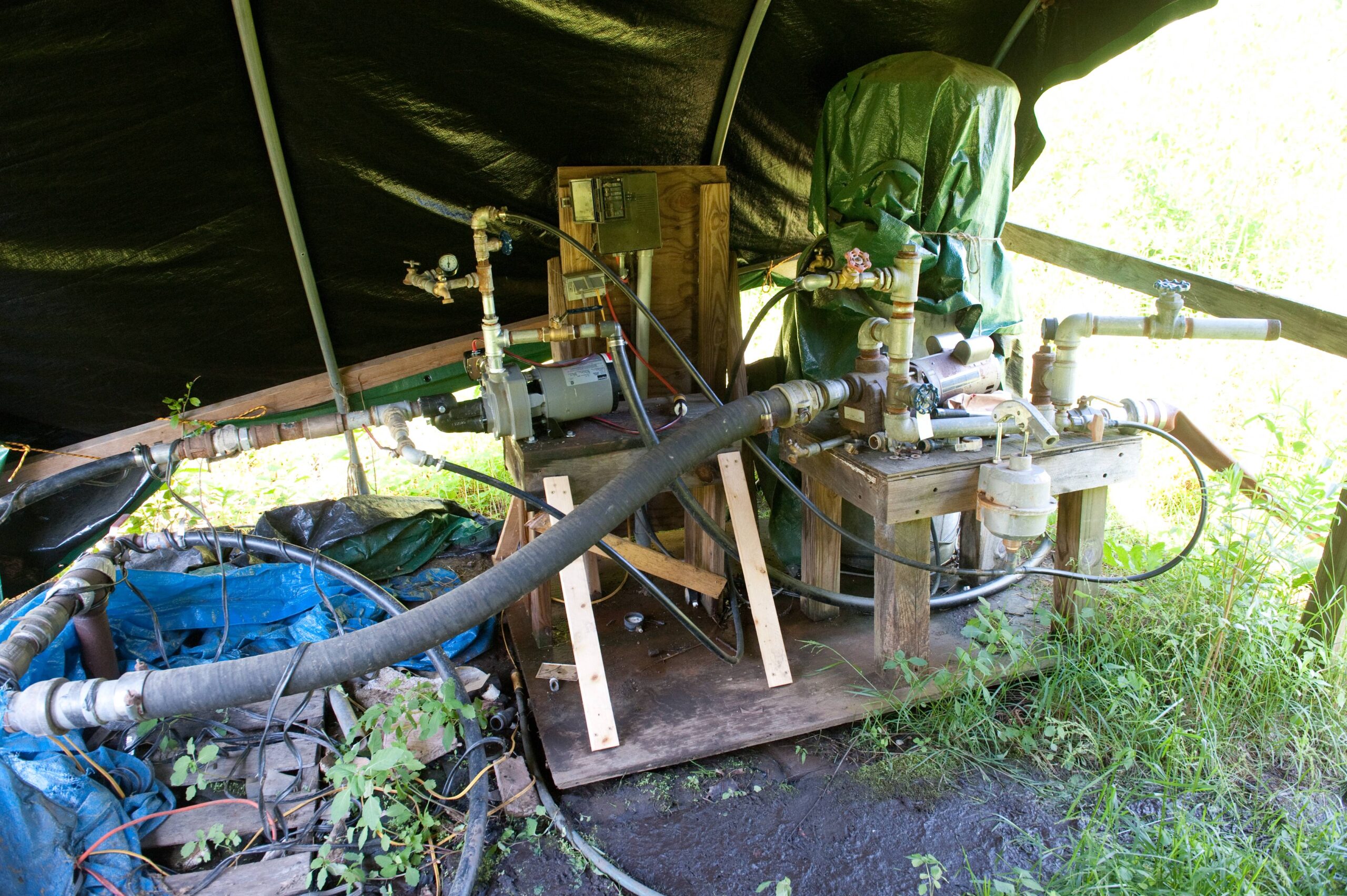 Photograph of two real well pumps, piping, valves and a pressure-controlled well water system